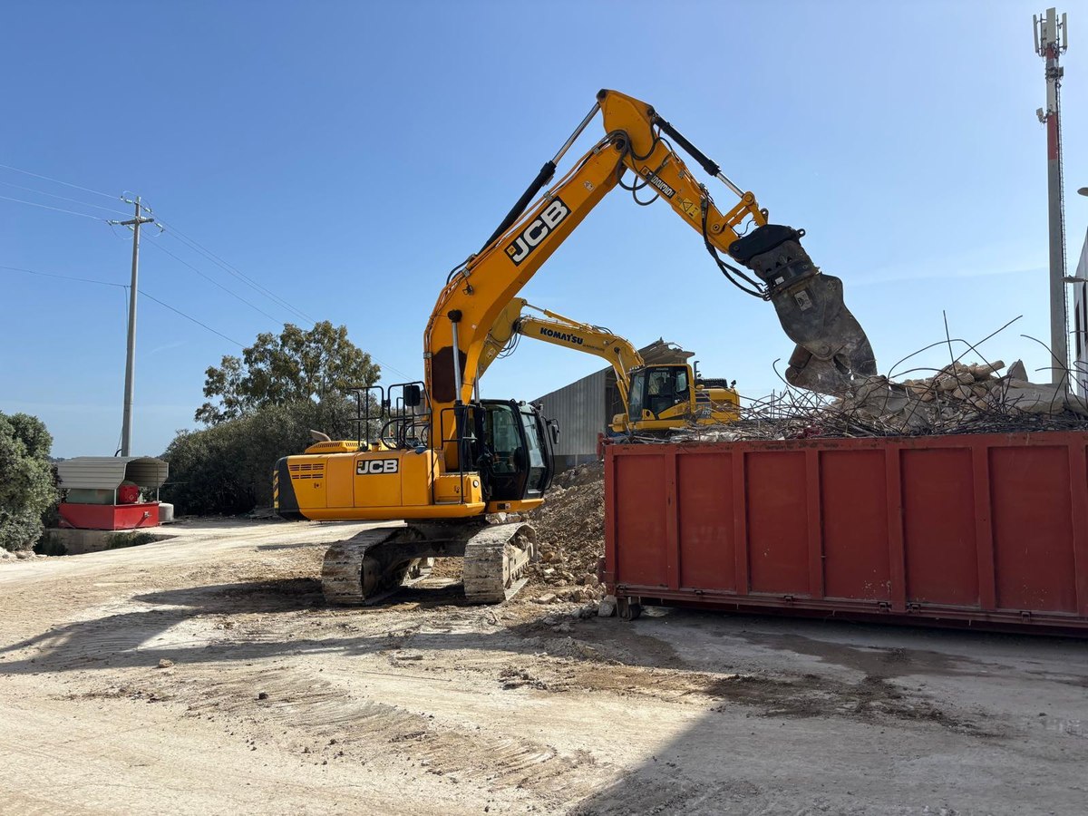 Escavatore carica materiale in un cassone per il trasporto